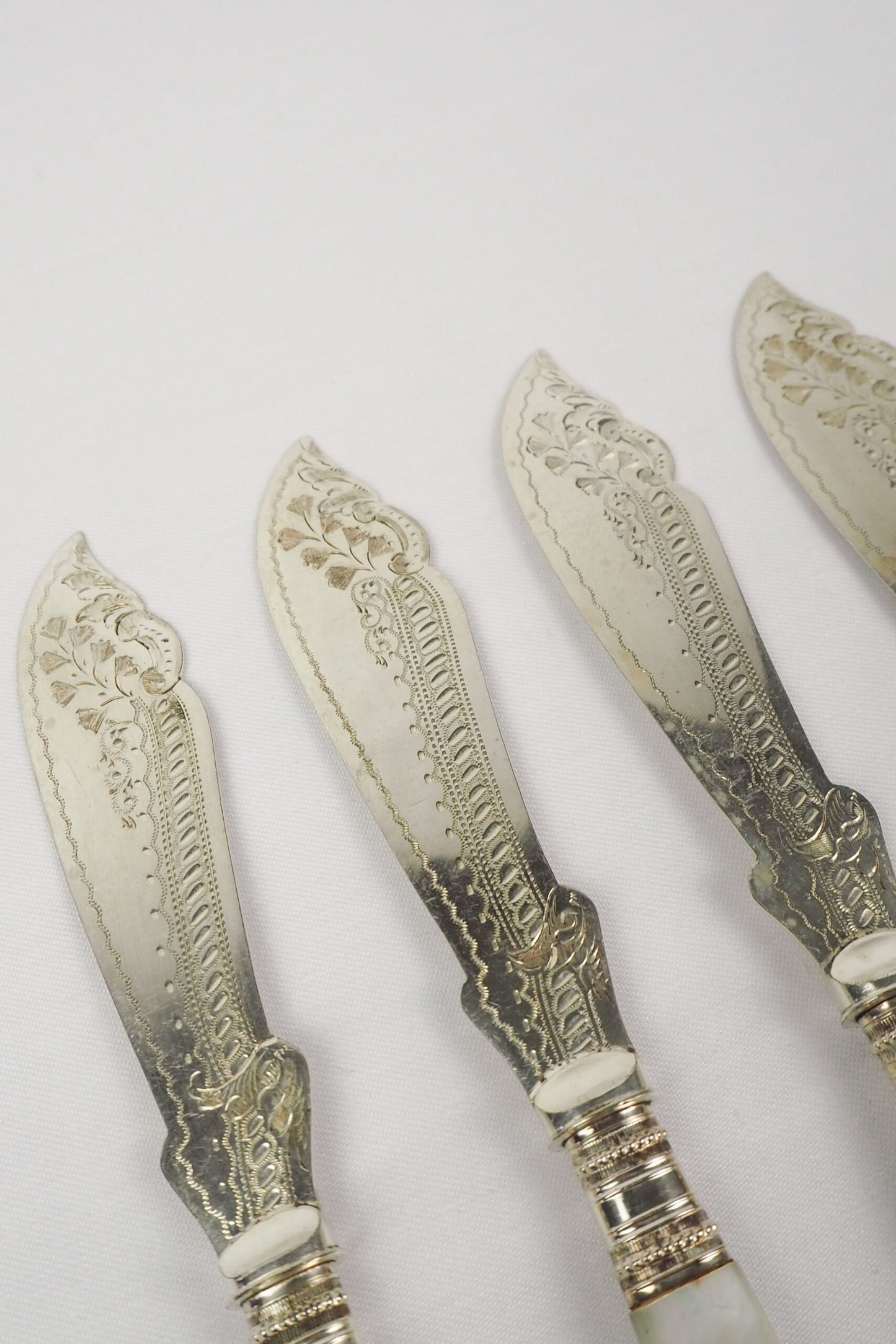 A Set of 4 Antique Silver Plate Fish Knives with mother of pearl handles. The blade of each Victorian Fish Knife has a beautifully etched floral pattern. Wildmore