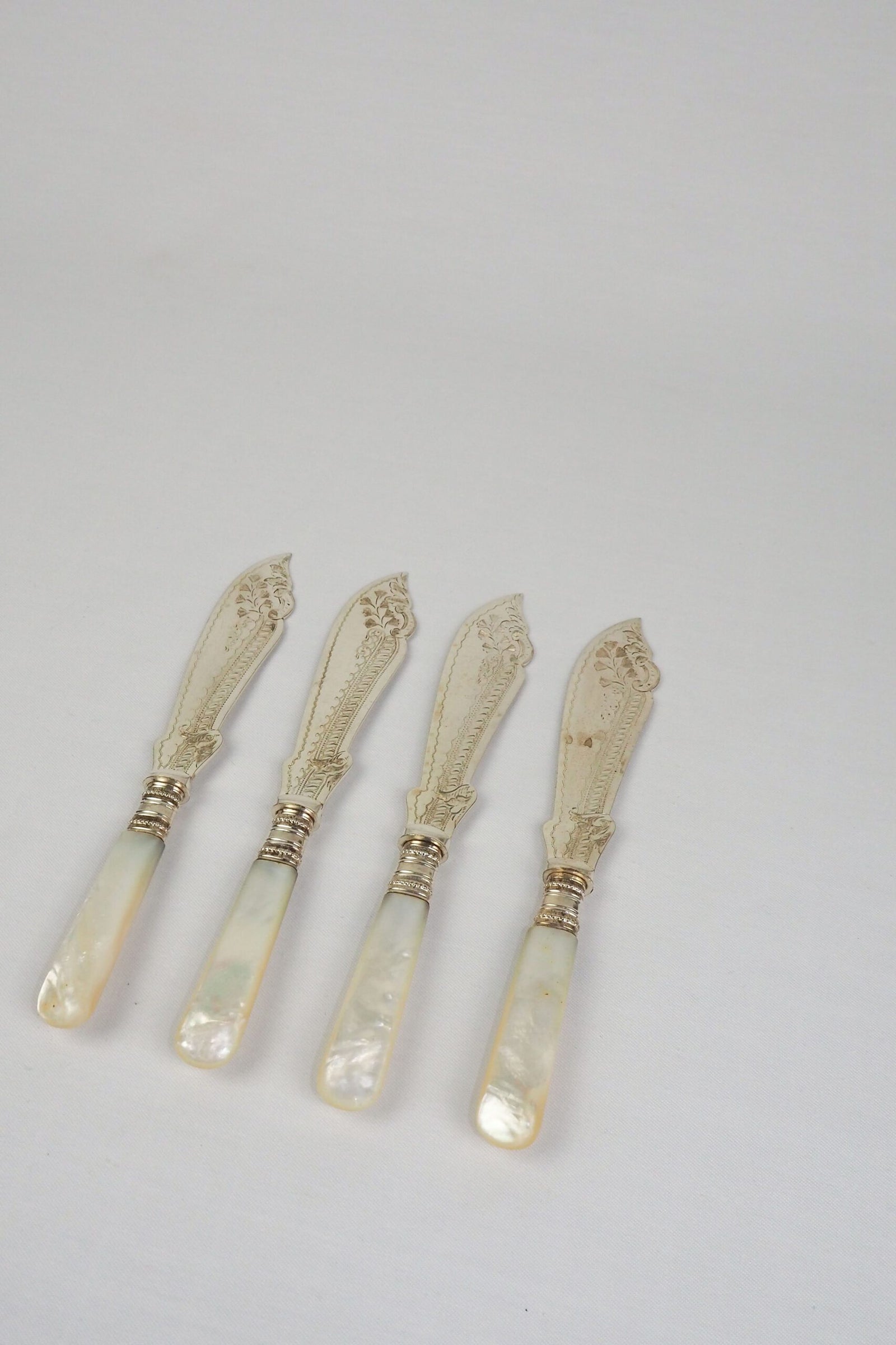 A Set of 4 Antique Silver Plate Fish Knives with mother of pearl handles. The blade of each Victorian Fish Knife has a beautifully etched floral pattern. Wildmore