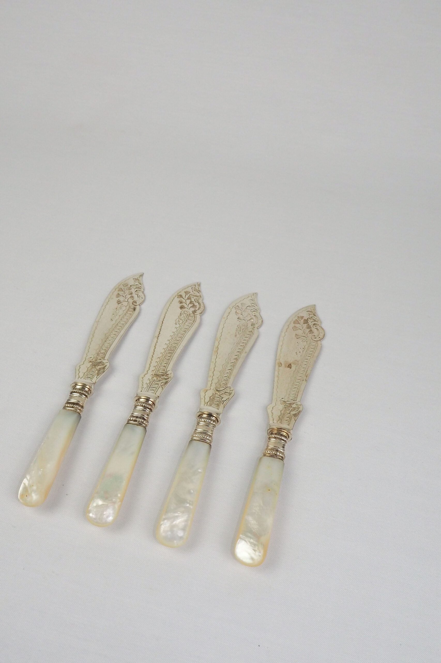 A Set of 4 Antique Silver Plate Fish Knives with mother of pearl handles. The blade of each Victorian Fish Knife has a beautifully etched floral pattern. Wildmore