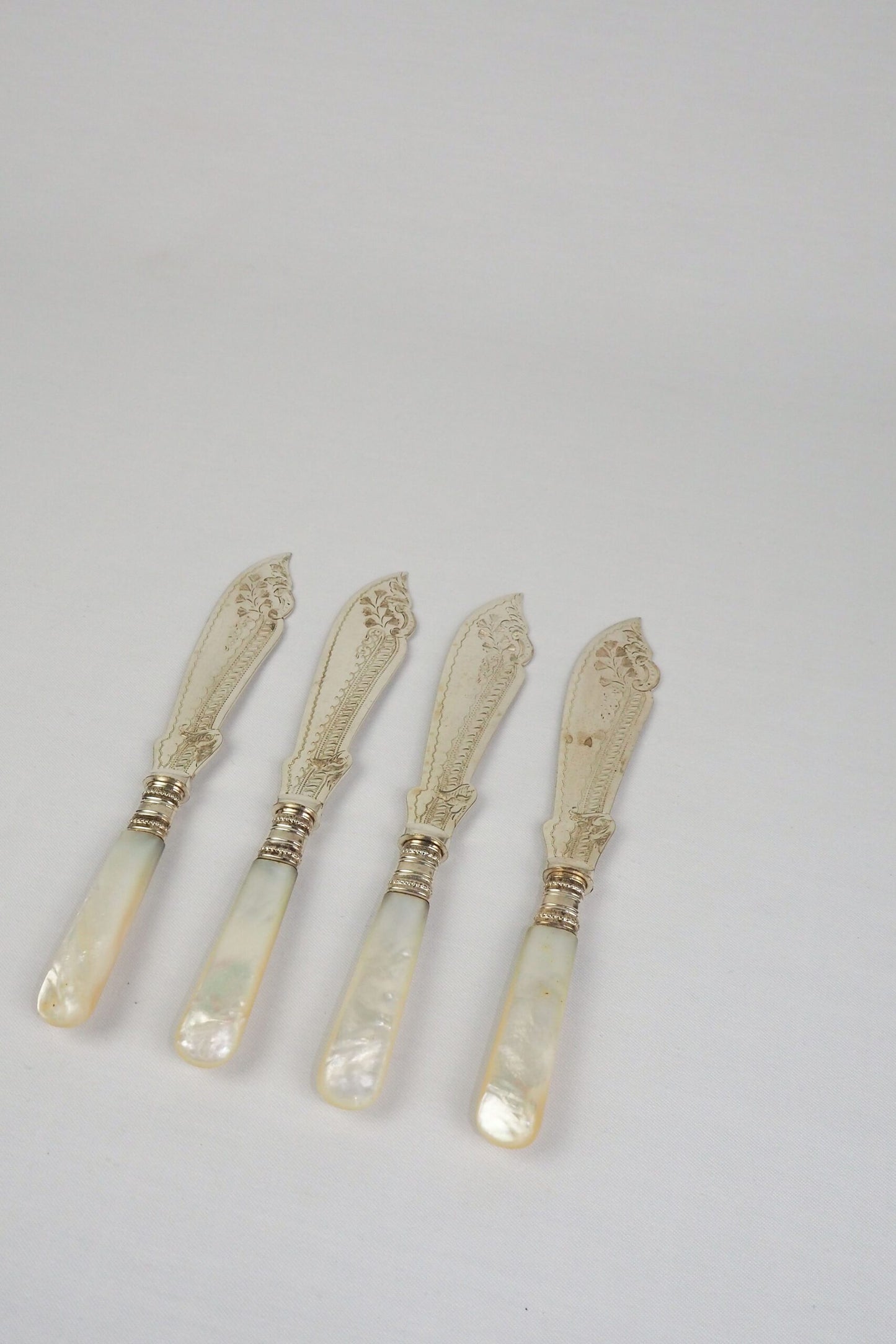 A Set of 4 Antique Silver Plate Fish Knives with mother of pearl handles. The blade of each Victorian Fish Knife has a beautifully etched floral pattern. Wildmore