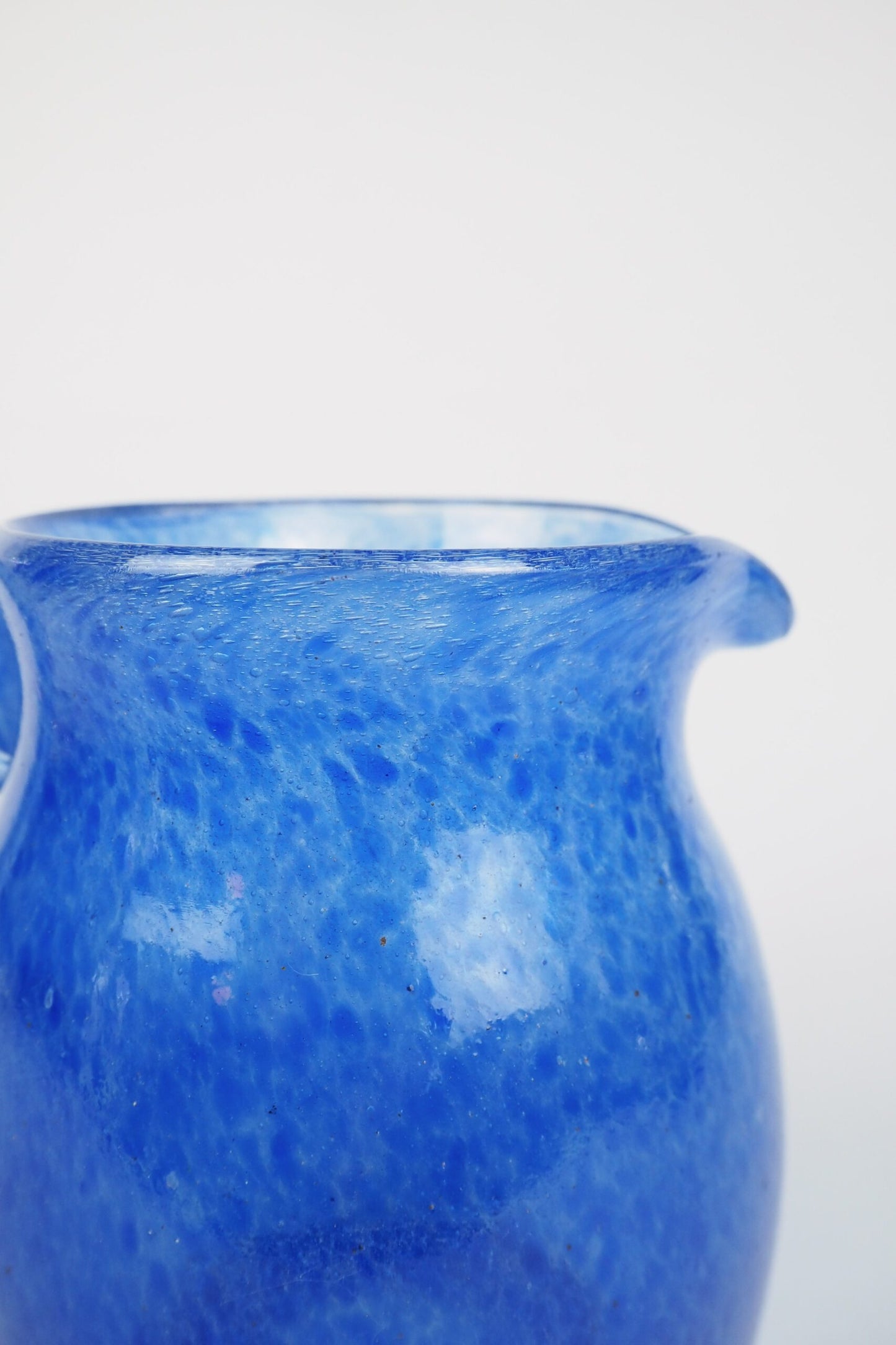 A hand blown Vintage Gass Jug with a blue speckle pattern and bubbles running through the glass. Wildmore