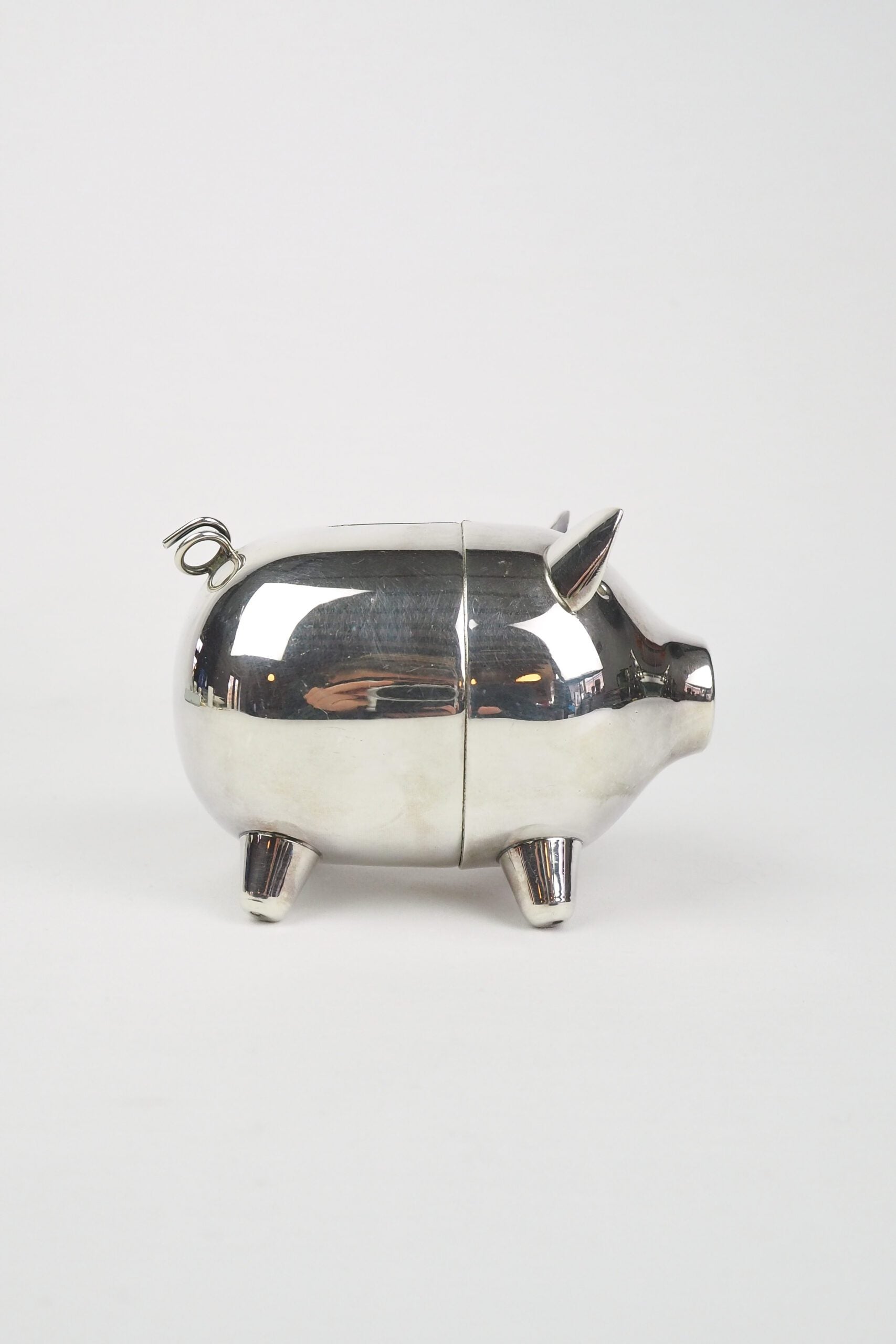 A wonderful Vintage Silver Plate Piggy Bank. This silver plated pig money box has a little curly tail and expressive ears. Wildmore