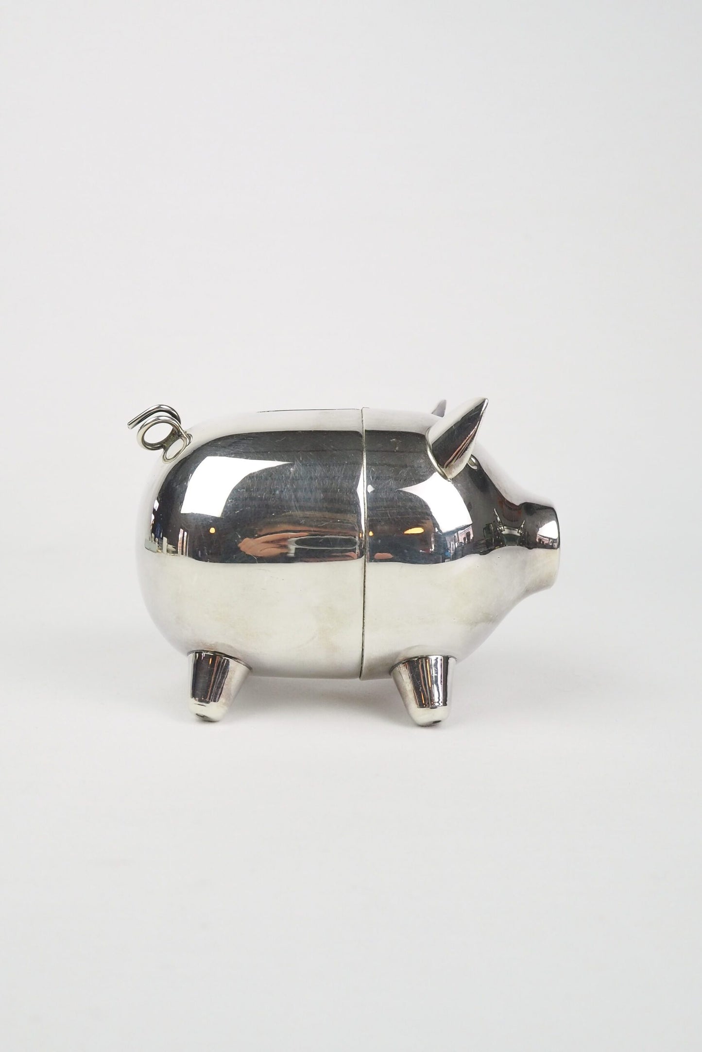 A wonderful Vintage Silver Plate Piggy Bank. This silver plated pig money box has a little curly tail and expressive ears. Wildmore