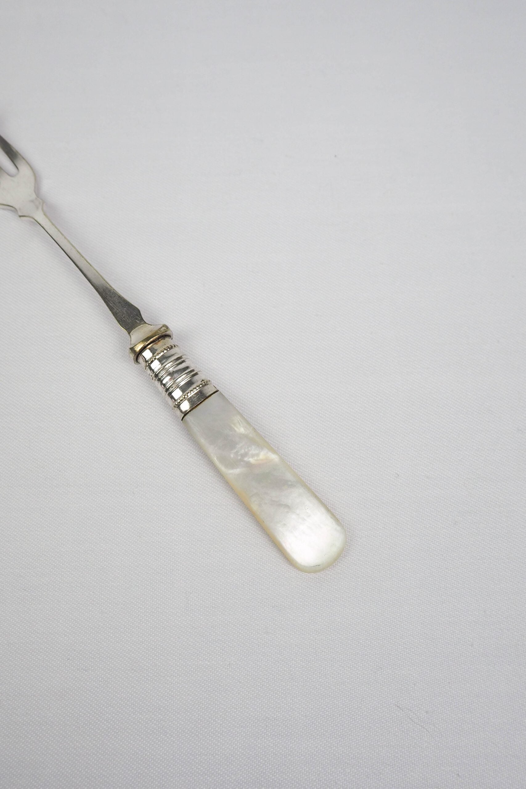 This Antique Pickle Fork has a beautiful Mother of Pearl handle, a Silver Plated neck and barbed prongs. Wildmore