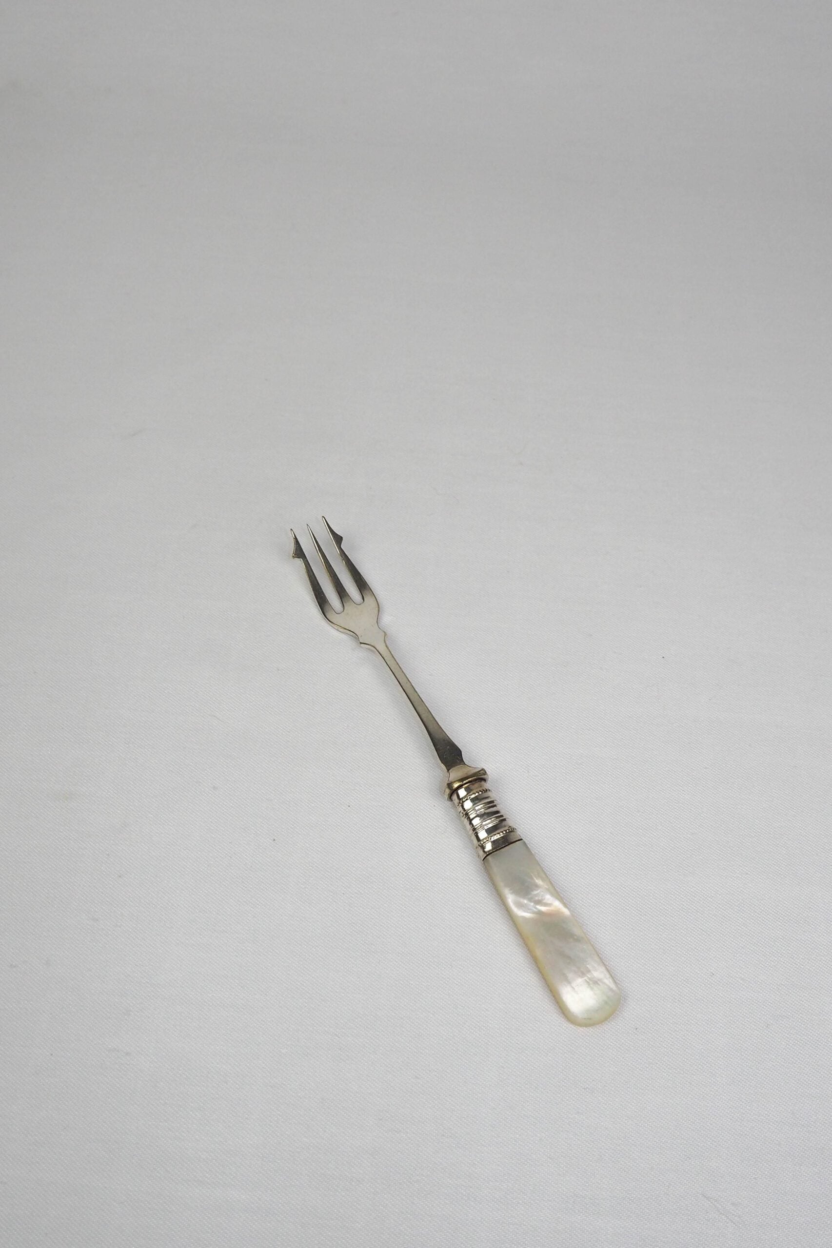 This Antique Pickle Fork has a beautiful Mother of Pearl handle, a Silver Plated neck and barbed prongs. Wildmore