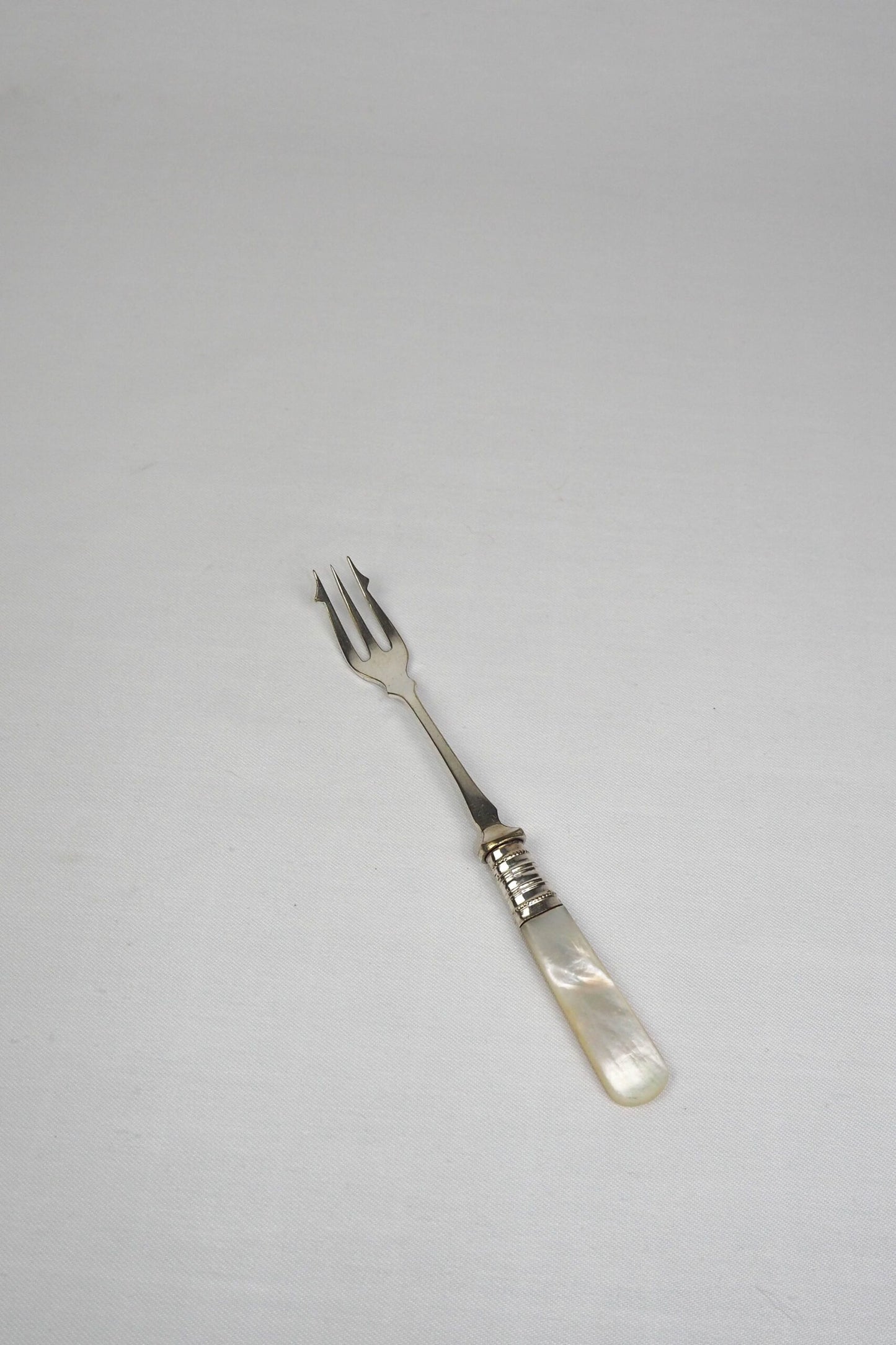 This Antique Pickle Fork has a beautiful Mother of Pearl handle, a Silver Plated neck and barbed prongs. Wildmore
