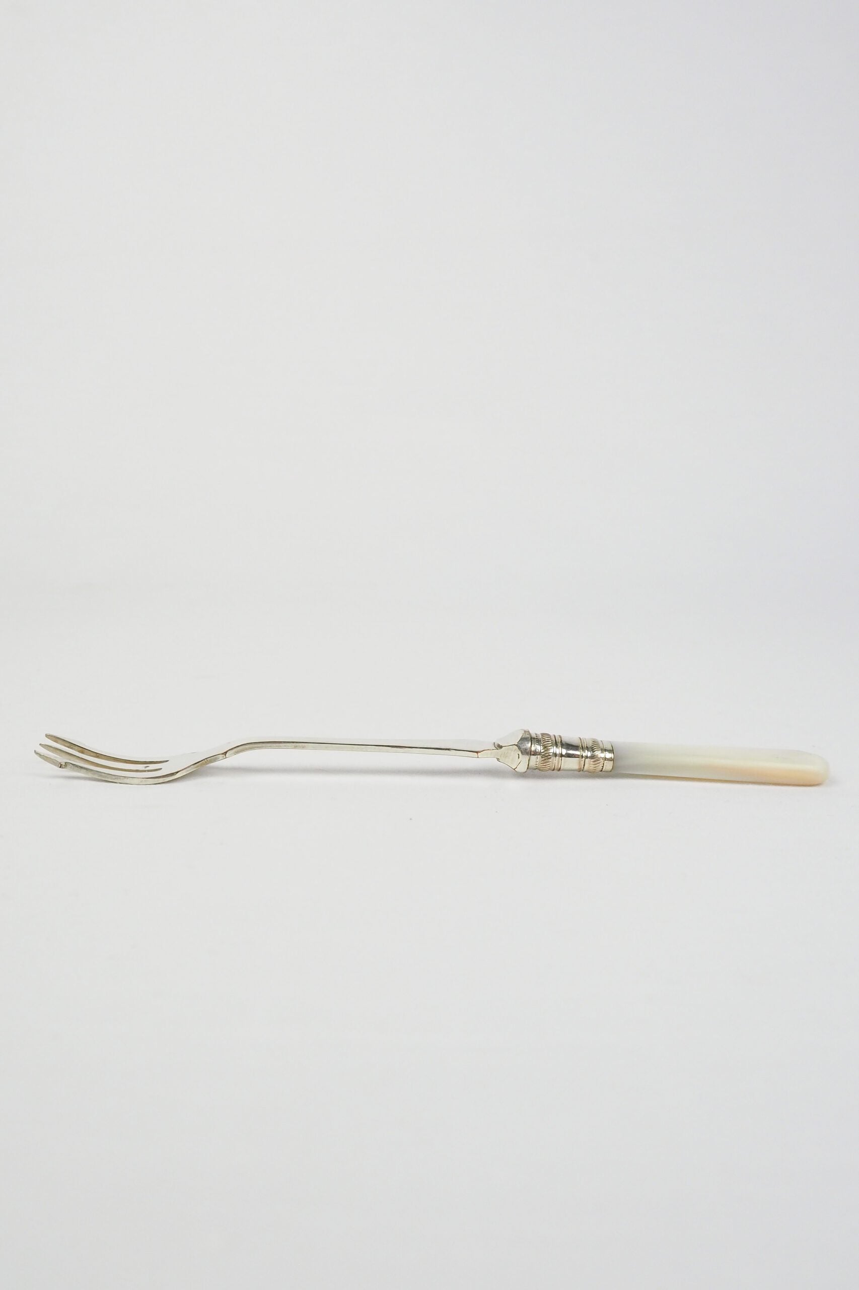This Antique Pickle Fork has a beautiful Mother of Pearl handle, a Silver Plated neck and barbed prongs. Wildmore