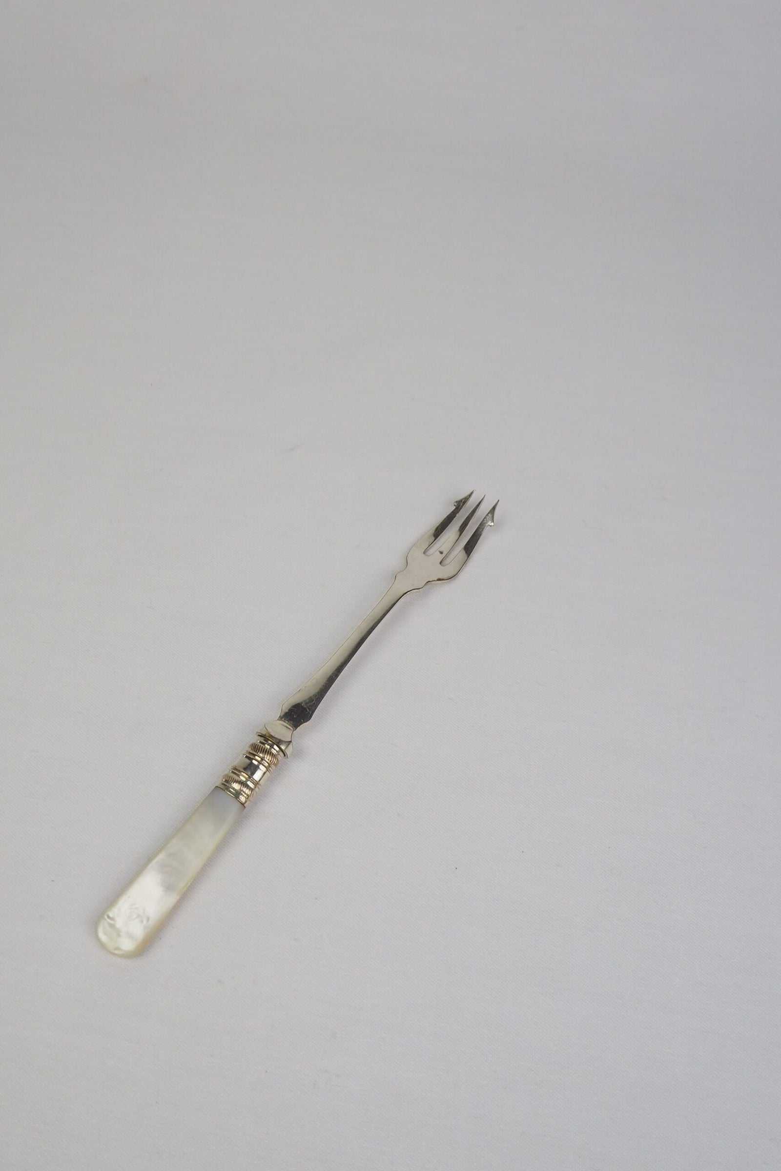 This Antique Pickle Fork has a beautiful Mother of Pearl handle, a Silver Plated neck and barbed prongs. Wildmore