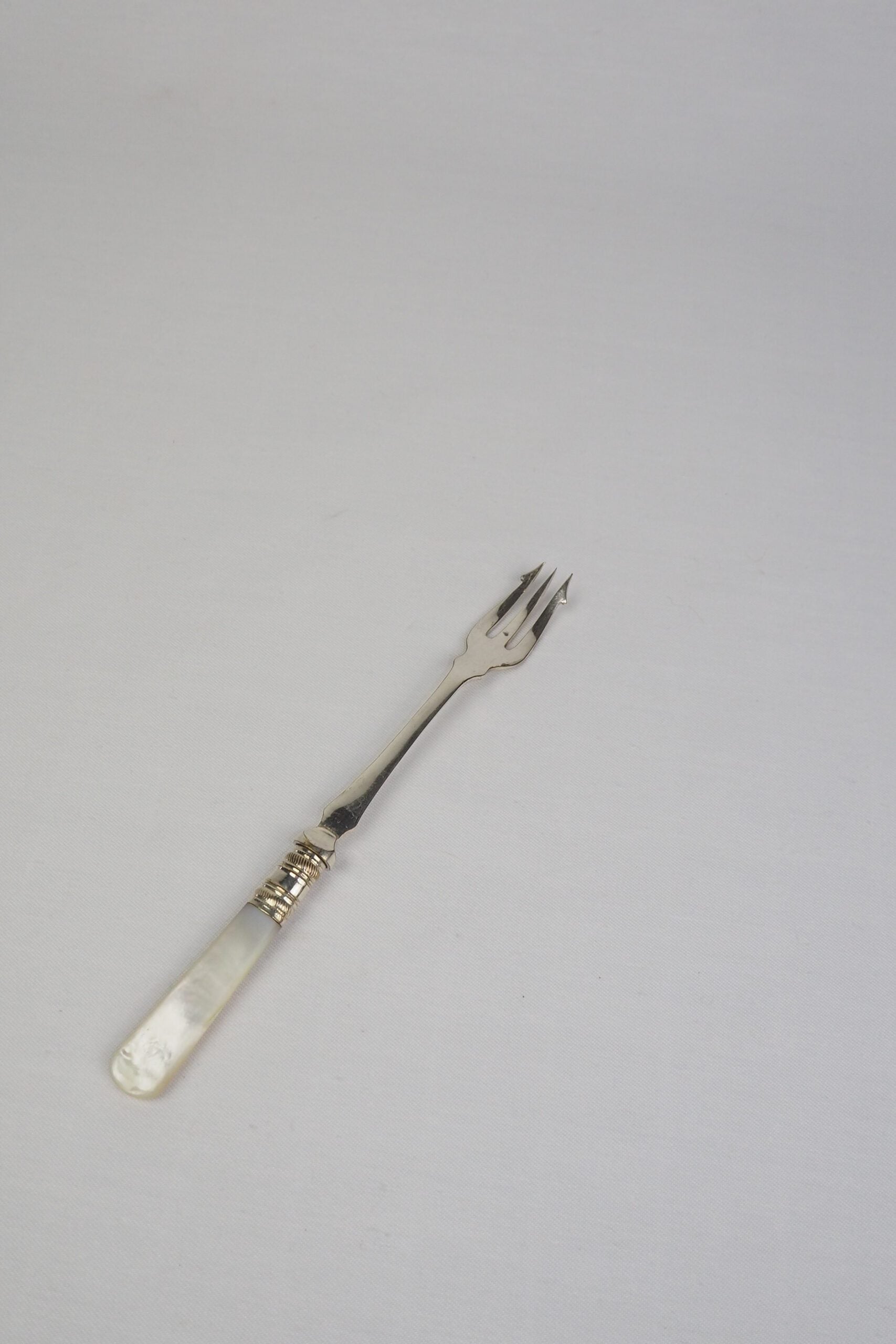 This Antique Pickle Fork has a beautiful Mother of Pearl handle, a Silver Plated neck and barbed prongs. Wildmore