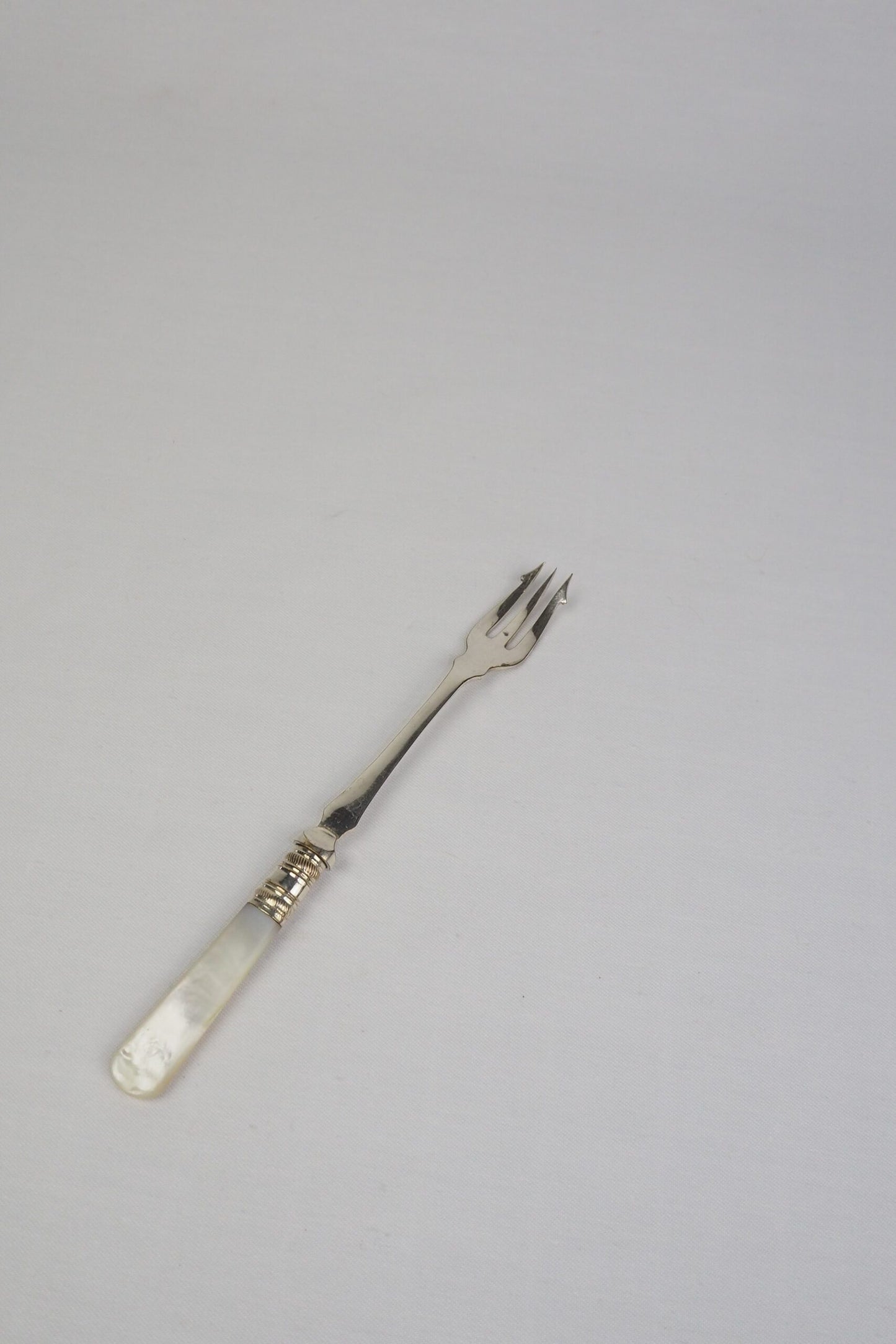 This Antique Pickle Fork has a beautiful Mother of Pearl handle, a Silver Plated neck and barbed prongs. Wildmore