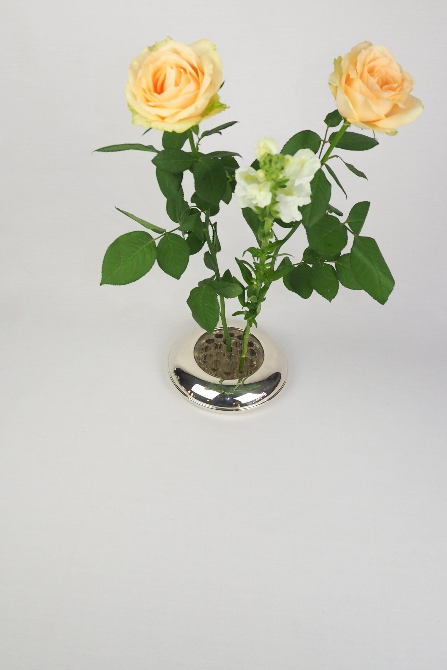 A vintage Silver Plate Flower Bowl with original glass flower frog. Filled with water, this mid century flower dish and flower frog is an elegant way to display your long stem flowers. Wildmore