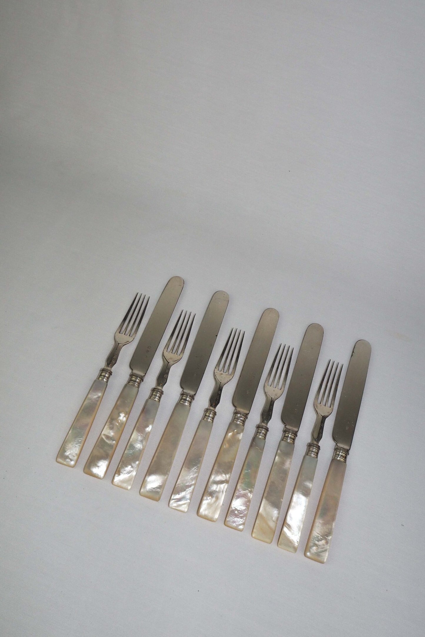 10 piece Antique Mother of Pearl Cutlery Set. The aged silver plate and mother of pearl handles give this set of knives and forks an antique look