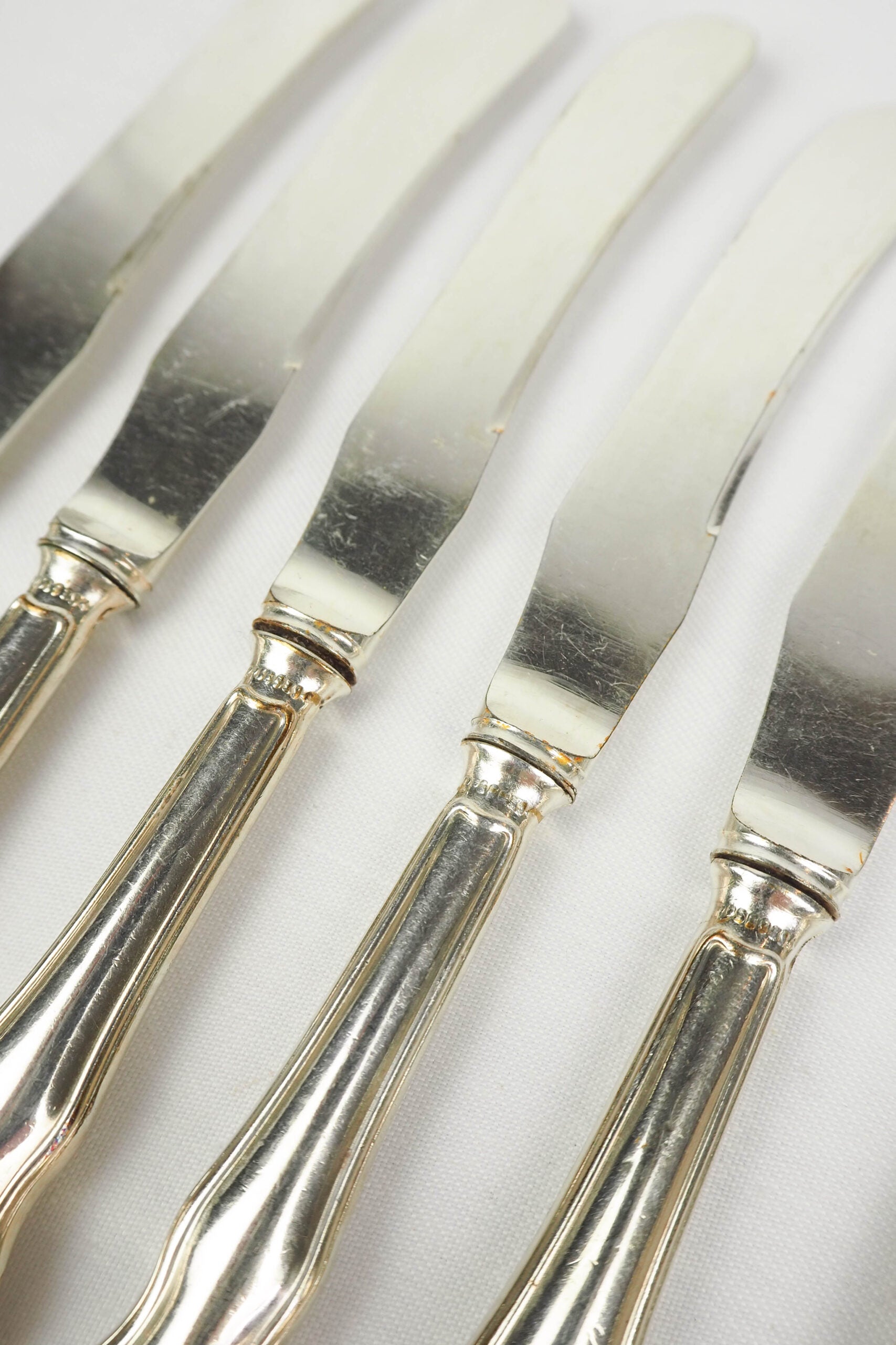 An Antique set of six Silver Plate Butter Knives with shapely tactile handles. 
