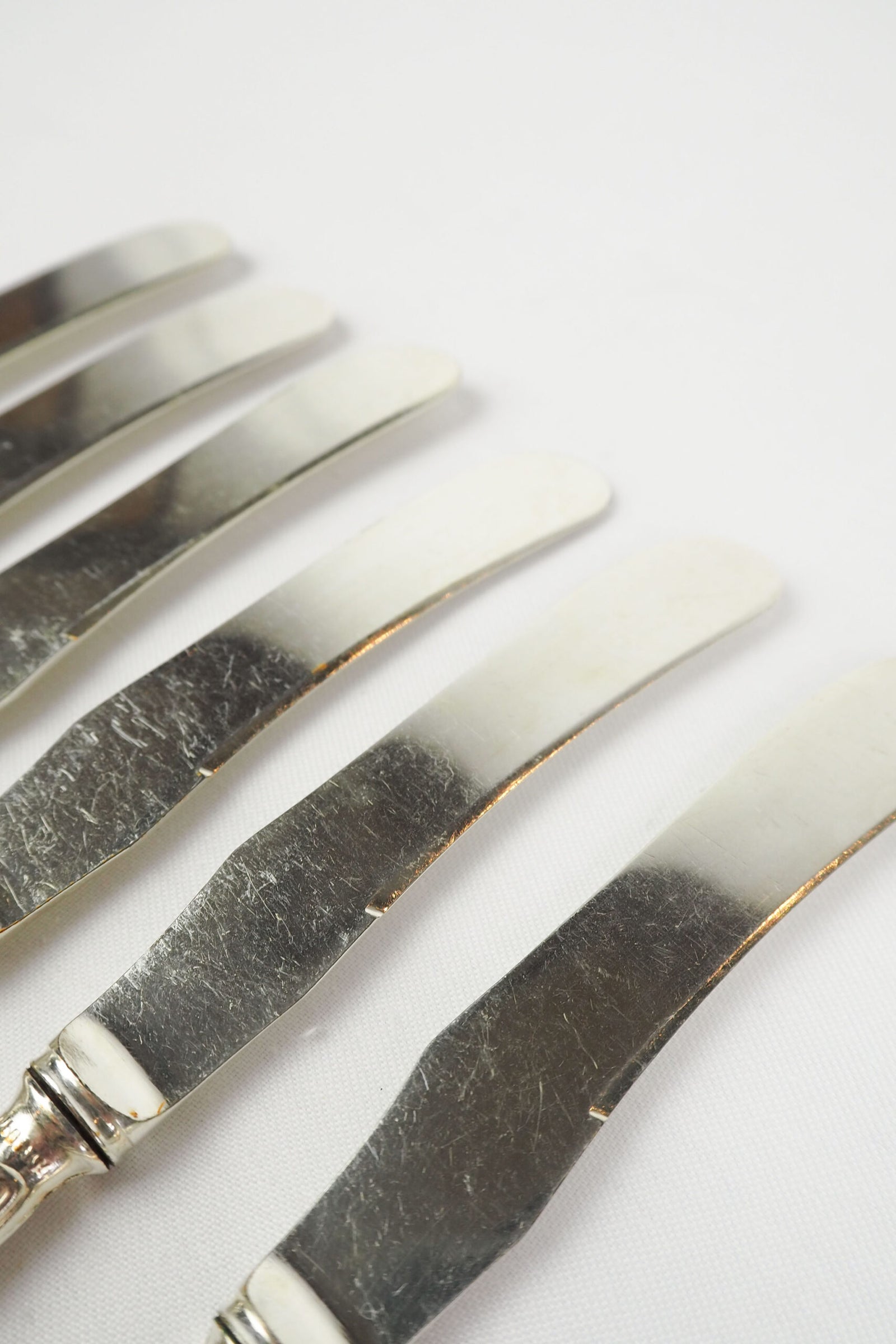 An Antique set of six Silver Plate Butter Knives with shapely tactile handles. 