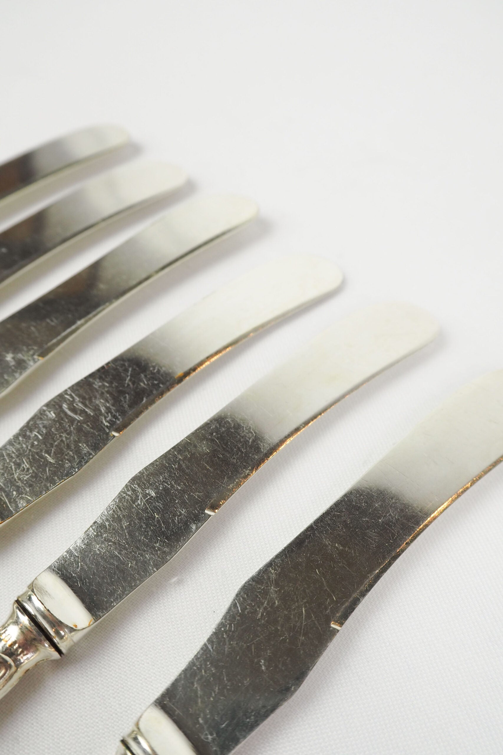 An Antique set of six Silver Plate Butter Knives with shapely tactile handles. 
