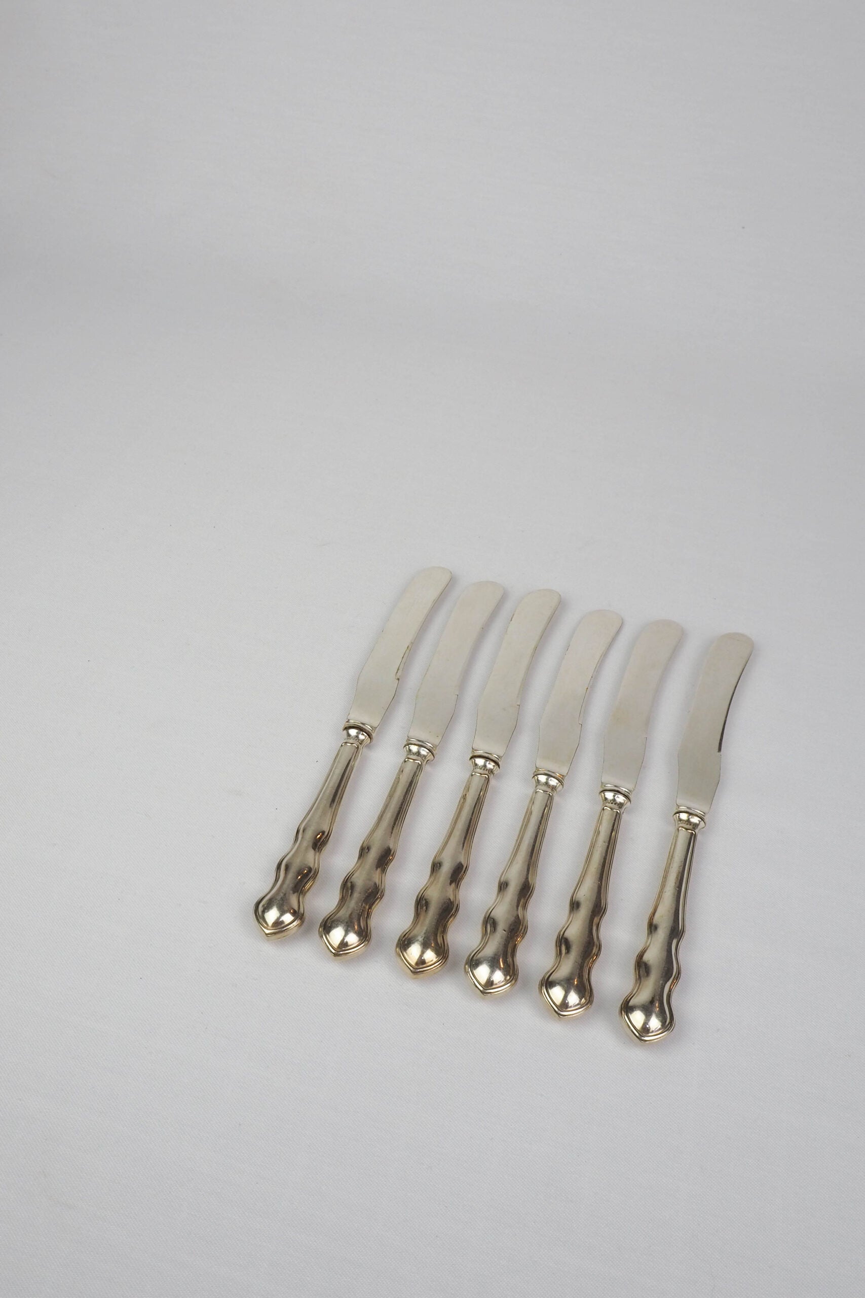 An Antique set of six Silver Plate Butter Knives with shapely tactile handles. 