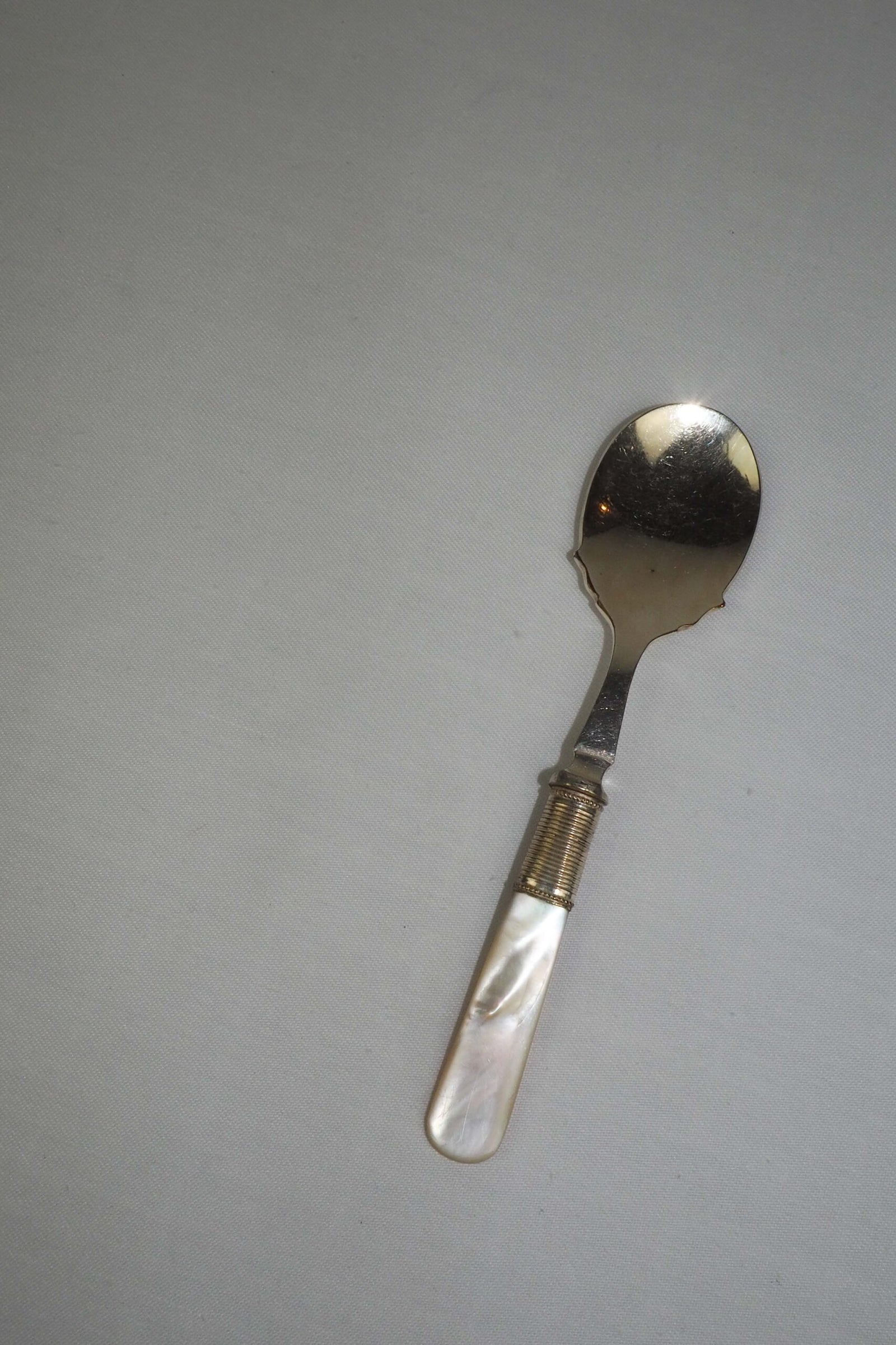 An Antique Jam Spoon With a Mother of Pearl handle and a Silver Plated neck and shallow bowl. An incredibly useful and beautiful piece of cutlery.