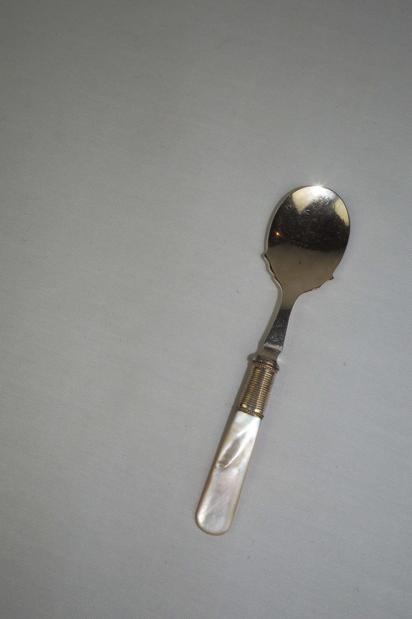 An Antique Jam Spoon With a Mother of Pearl handle and a Silver Plated neck and shallow bowl. An incredibly useful and beautiful piece of cutlery.