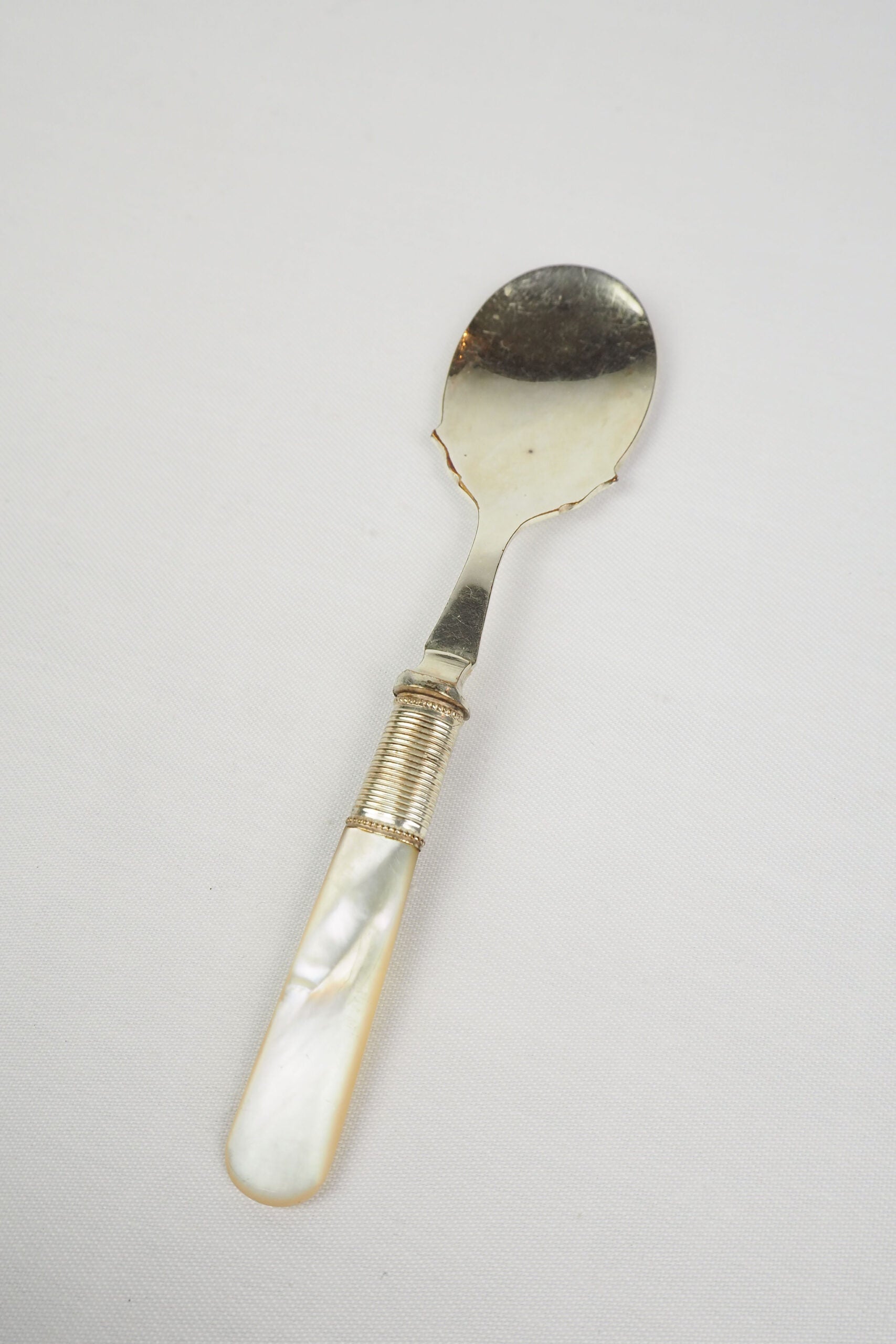 An Antique Jam Spoon With a Mother of Pearl handle and a Silver Plated neck and shallow bowl. An incredibly useful and beautiful piece of cutlery.