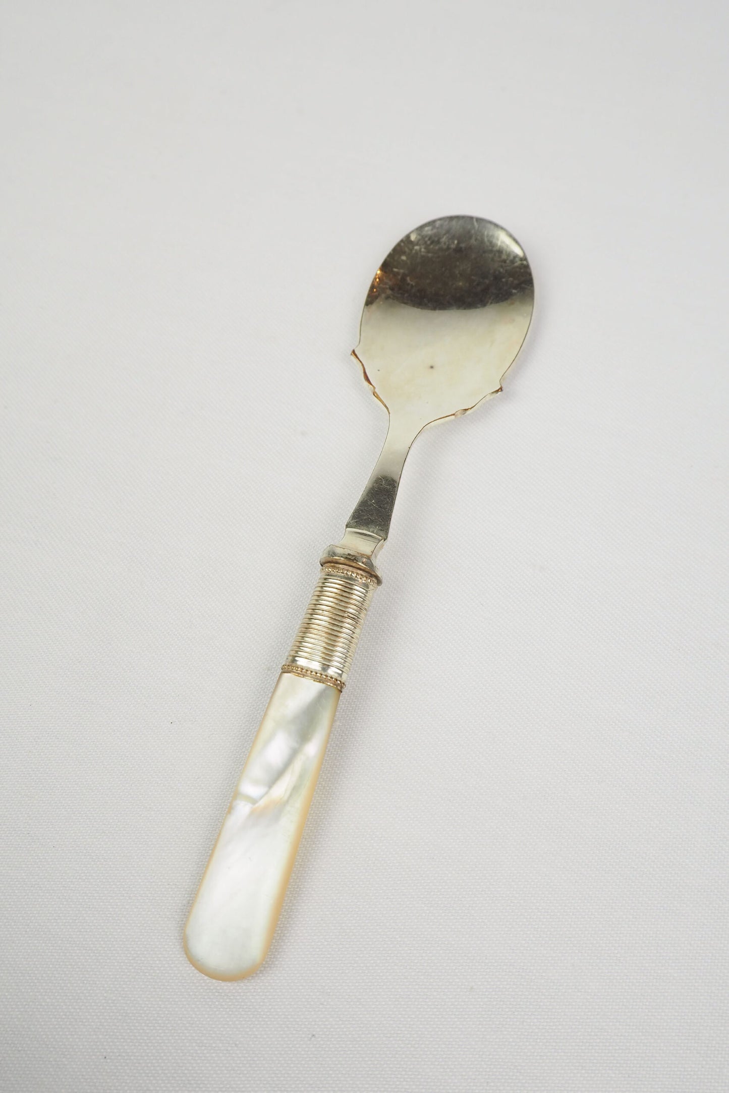 An Antique Jam Spoon With a Mother of Pearl handle and a Silver Plated neck and shallow bowl. An incredibly useful and beautiful piece of cutlery.