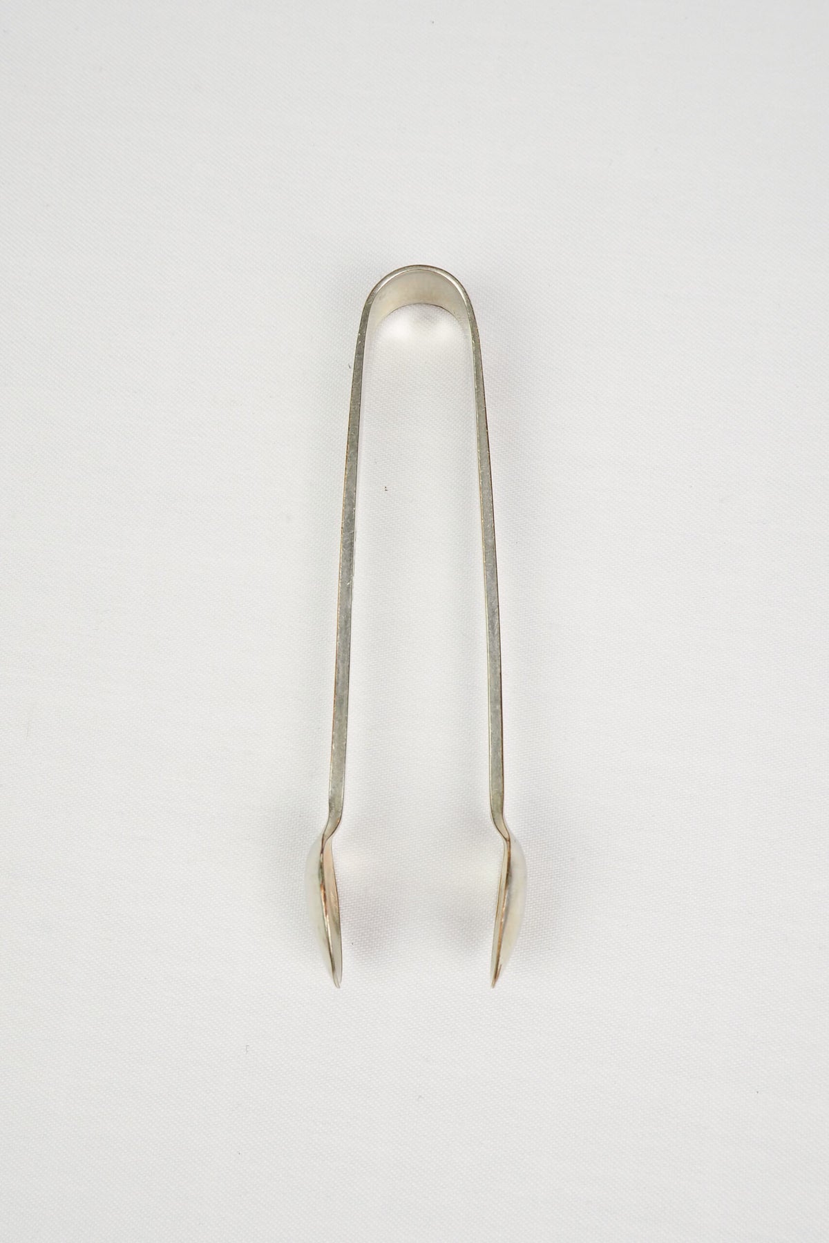 This Vintage Set of Silver Plate Sugar Tongs have a vintage stone washed patina to the silver plate and a decorative etched floral pattern. 