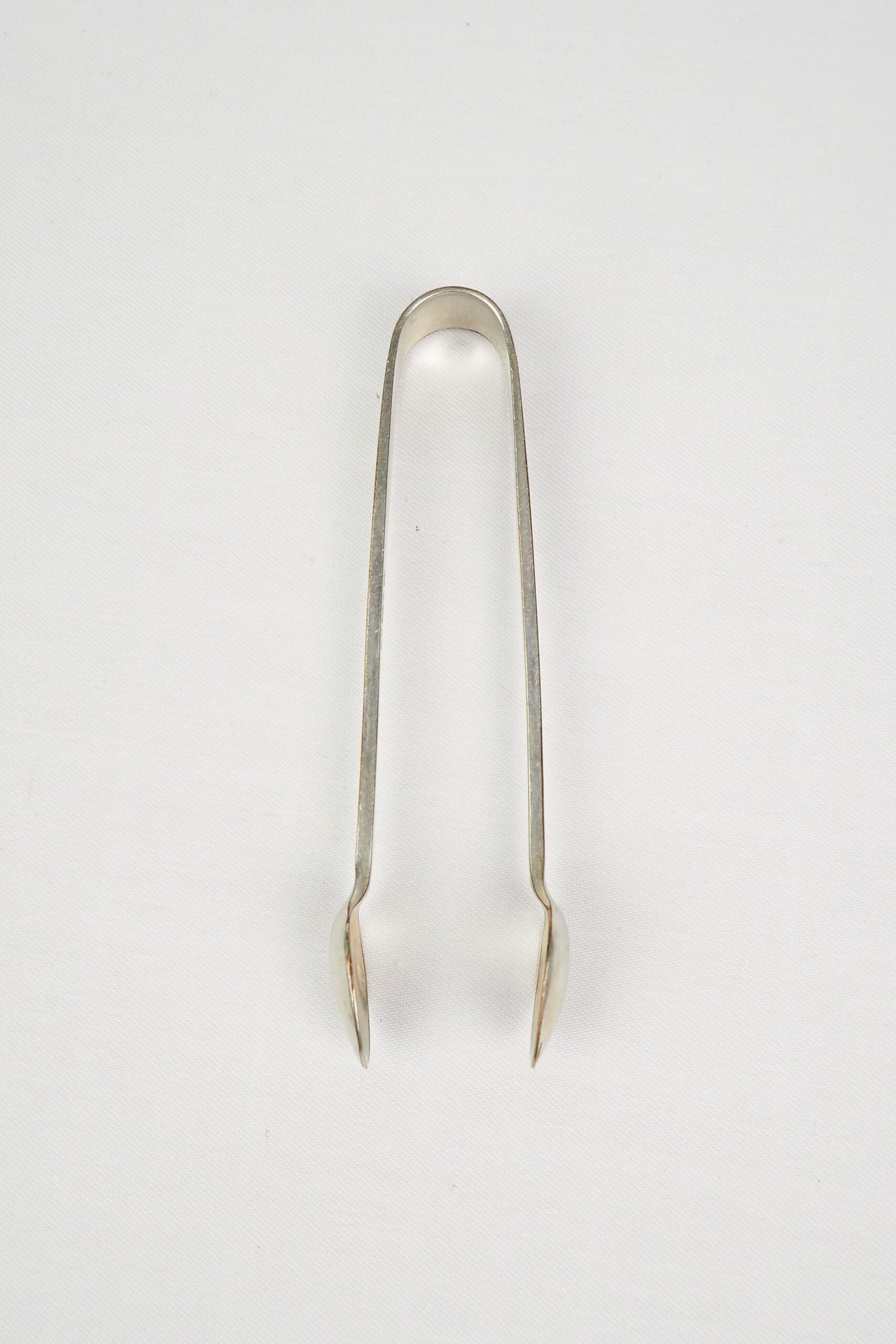 This Vintage Set of Silver Plate Sugar Tongs have a vintage stone washed patina to the silver plate and a decorative etched floral pattern. 