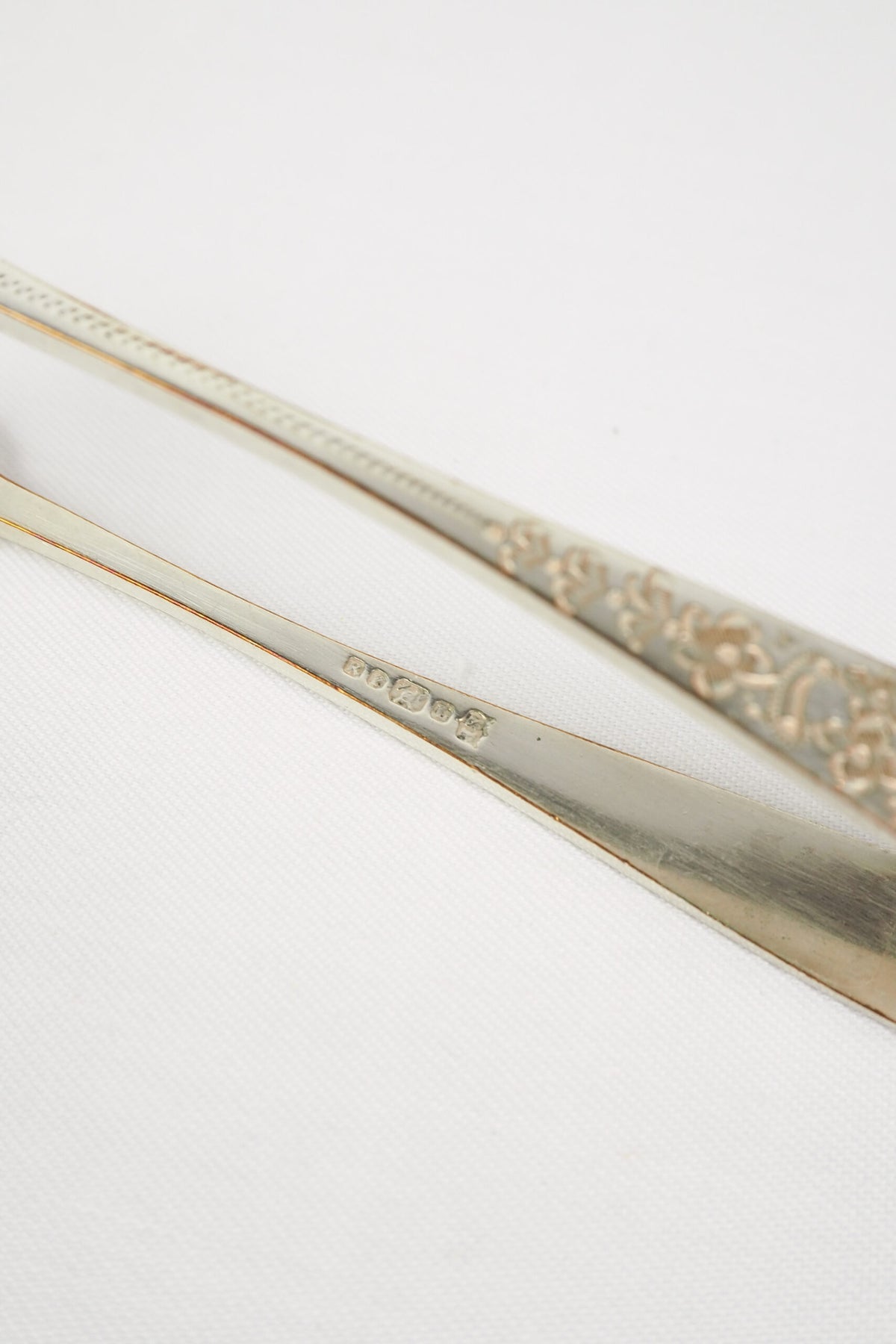 This Vintage Set of Silver Plate Sugar Tongs have a vintage stone washed patina to the silver plate and a decorative etched floral pattern. 