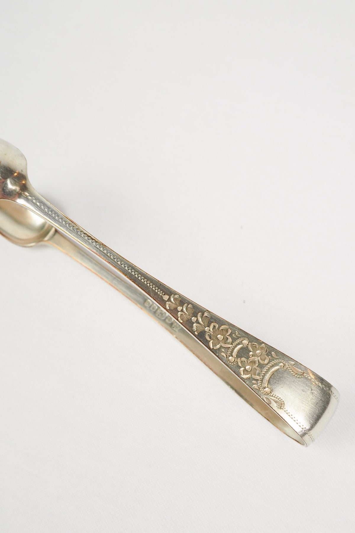 This Vintage Set of Silver Plate Sugar Tongs have a vintage stone washed patina to the silver plate and a decorative etched floral pattern. 