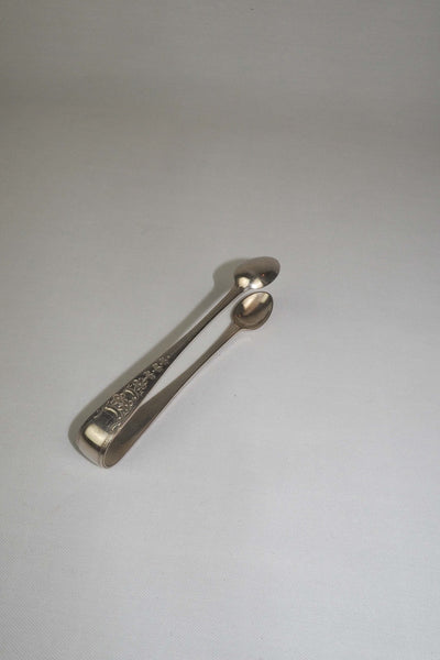 This Vintage Set of Silver Plate Sugar Tongs have a vintage stone washed patina to the silver plate and a decorative etched floral pattern. 