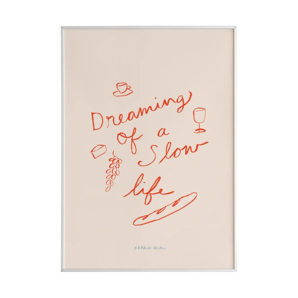 This mini art print features the phrase “Dreaming of a Slow Life” playfully surrounded by wine, cheese, grapes and a baguette painted in red on a white background. 