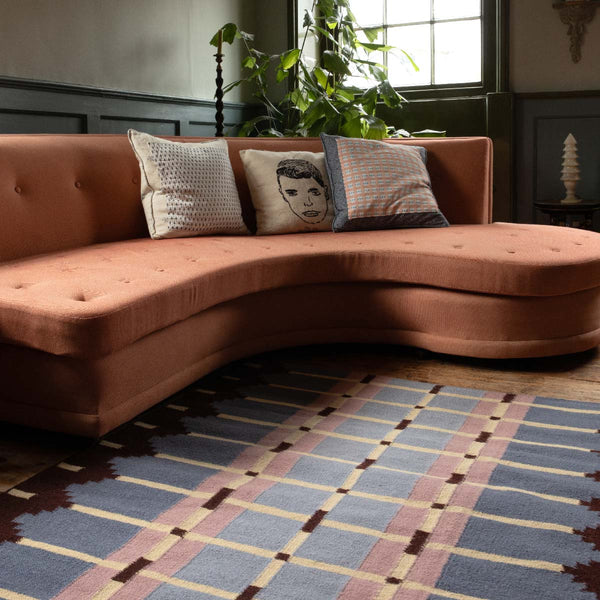Pigeon Blue Corbie flatweave rug in dusky periwinkle blue styled in a characterful living room.