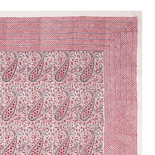 Pink block printed tablecloth with paisley pattern on a white background