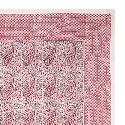 Pink block printed tablecloth with paisley pattern on a white background