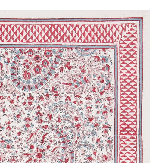 A hand-block printed pink and white floral patterned table mat.