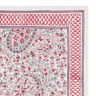 A hand-block printed pink and white floral patterned table mat.