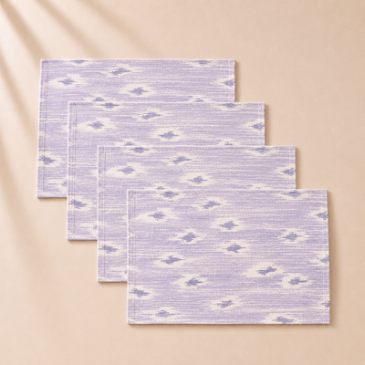 Set of four purple and white patterned placemats on a beige background