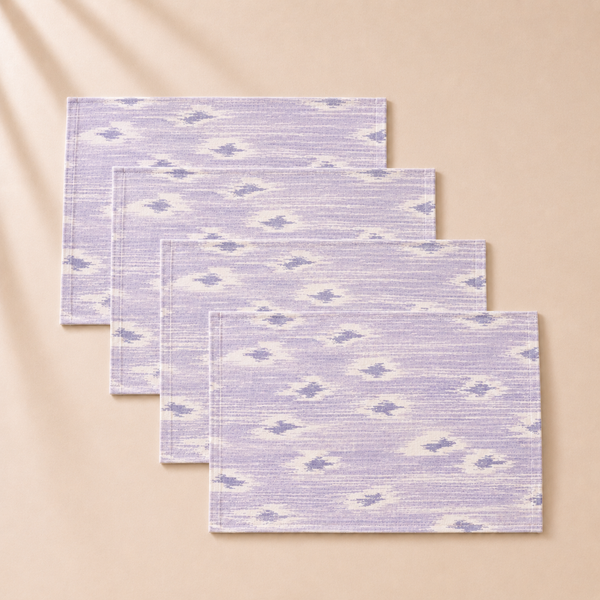 Set of four purple and white patterned placemats on a beige background