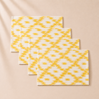 Set of three yellow and white patterned placemats on a beige background