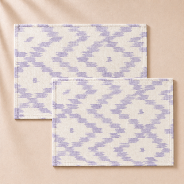 Two purple and white patterned placemats on a beige background