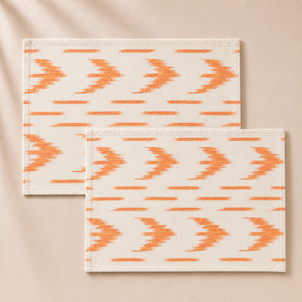 Two orange and white patterned placemats on a beige background