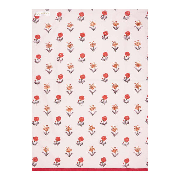 A cotton tea towel with a hand-block printed floral pattern in red and orange on a white background, crafted by artisans.