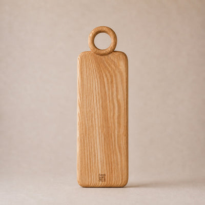 Wooden cutting board with round handle on a beige background