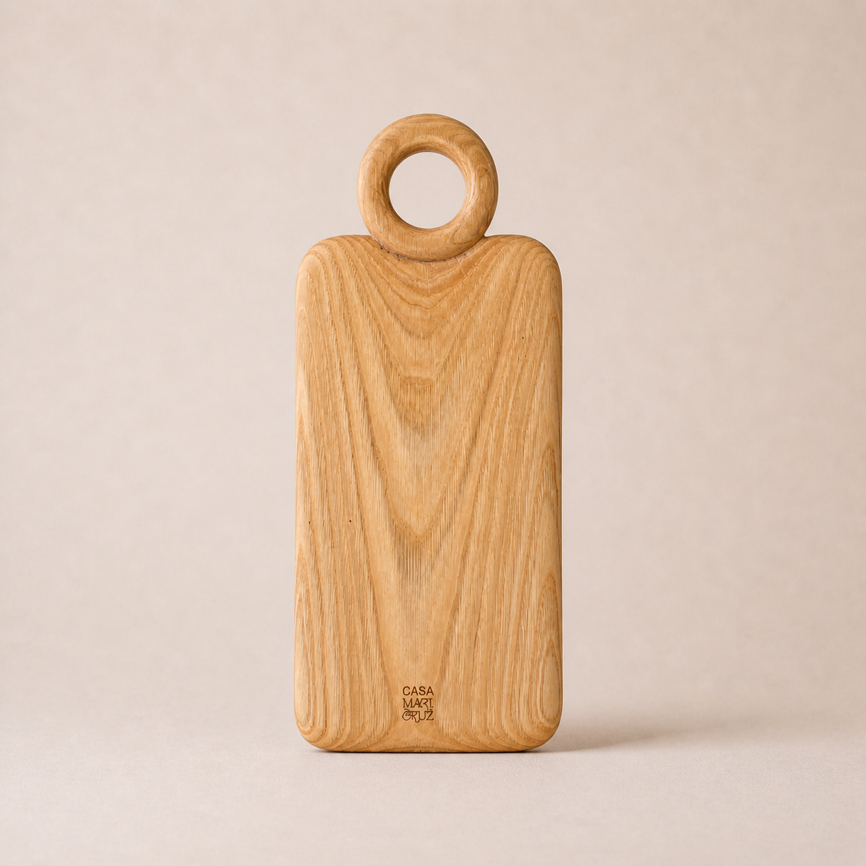 Wooden cutting board with ring handle on a beige background