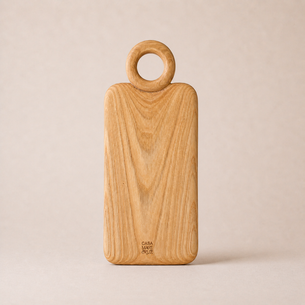 Wooden cutting board with ring handle on a beige background