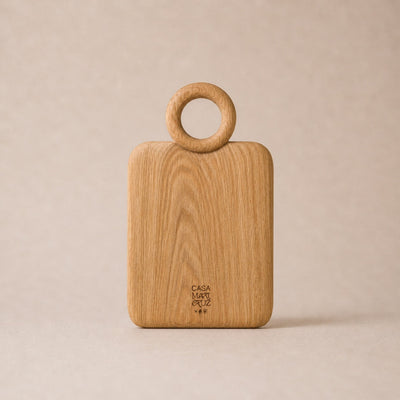 Wooden cutting board with ring handle on a beige background