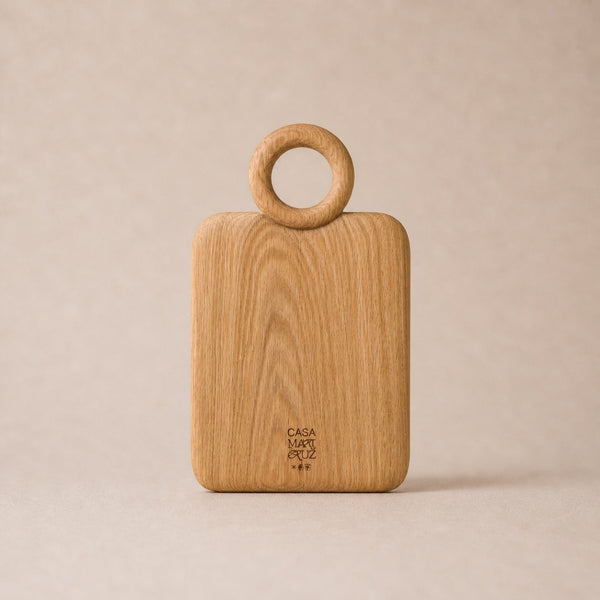 Wooden cutting board with ring handle on a beige background