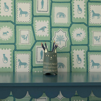 Folk Tales wallpaper in pistachio green with illustrated animal pattern shown in situ.