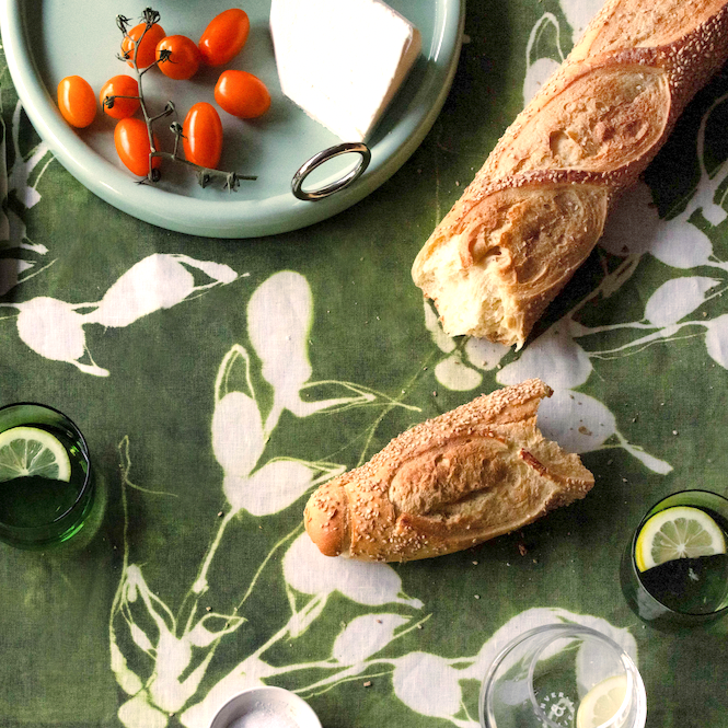 Porto Print Olive linen tablecloth styled on dining table with warm natural setting - Goldie Home