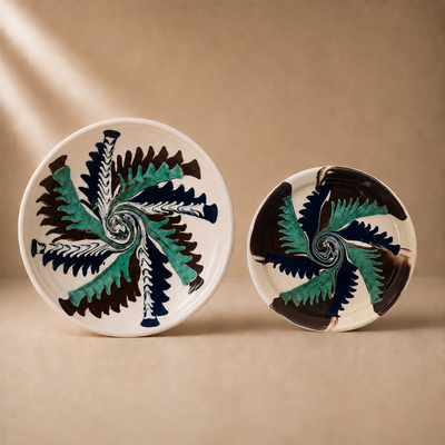 Two ceramic plates with decorative leaf patterns on a beige background