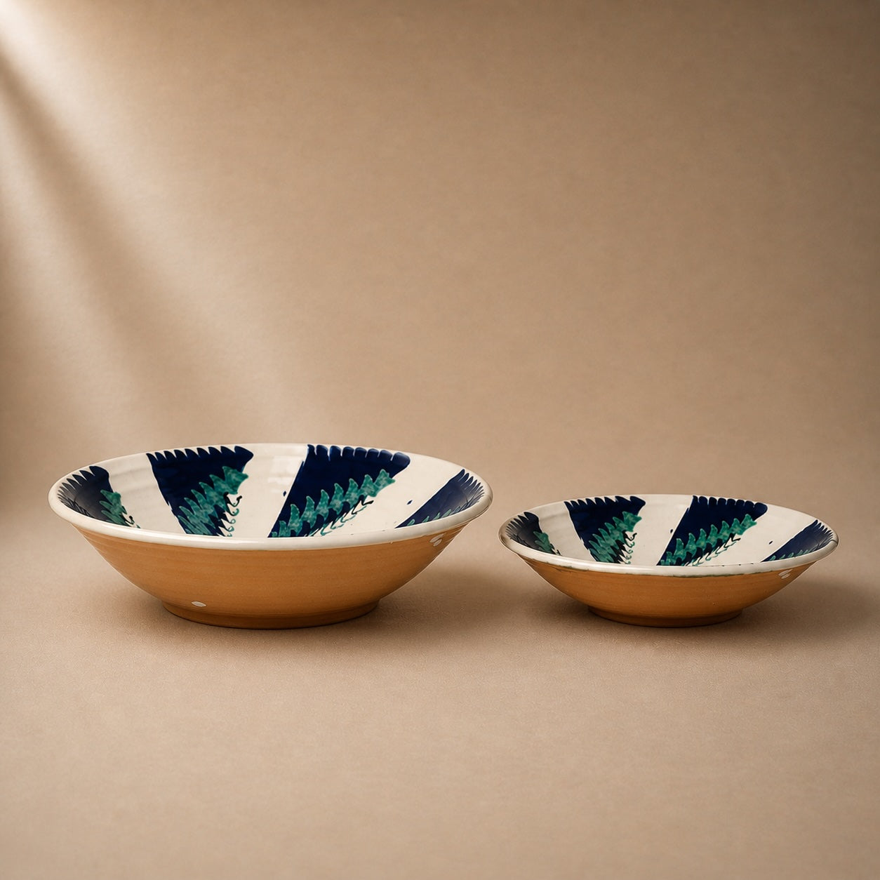 Two ceramic bowls with striped patterns on a beige background